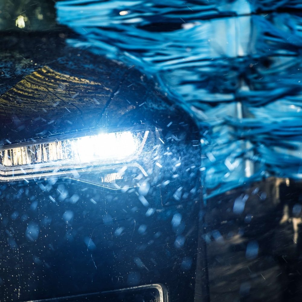 Modern Vehicle in the Automatic Brush Car Wash Closeup Photo.